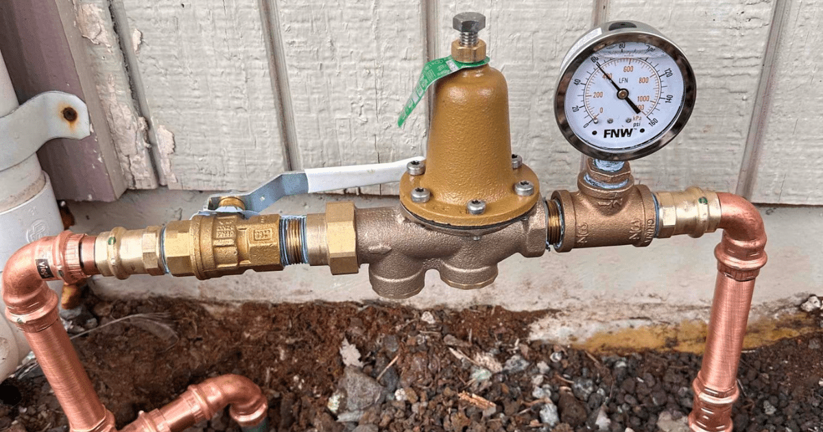 Gas line with a pressure regulator on an exterior wall