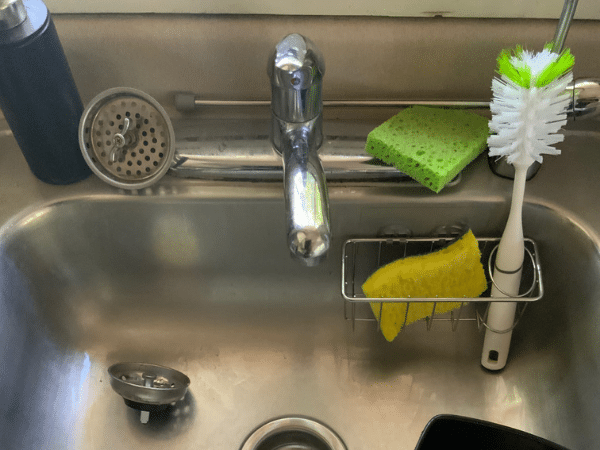 Kitchen sink with faucet and cleaning supplies